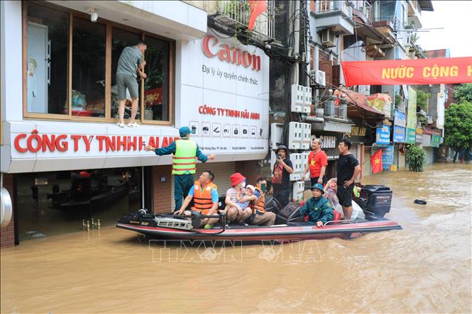  Hàng trăm người được huy động hỗ trợ người dân di chuyển đến nơi an toàn. Ảnh: Tuấn Anh - TTXVN