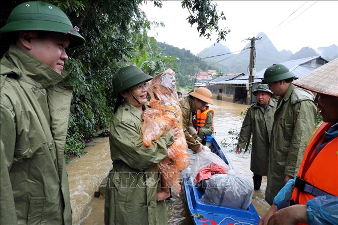 Hai mẹ con chị Lành Thị Hương Huệ ở xóm Lùm Thúm, thôn Đoàn Kết, xã Tân Đoàn vừa được lực lượng chức năng địa phương đưa từ vùng ngập sâu lên bờ ngày 30/9. Ảnh: Văn Đạt - TTXVN
