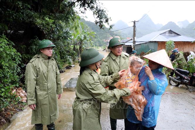 Hai mẹ con chị Lành Thị Hương Huệ ở xóm Lùm Thúm, thôn Đoàn Kết, xã Tân Đoàn vừa được lực lượng chức năng địa phương đưa từ vùng ngập sâu lên bờ ngày 30/9. Ảnh: Văn Đạt - TTXVN