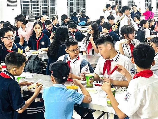 Học sinh trường THCS Giảng Võ được nhà trường tổ chức cho ăn tối khi chưa được bố mẹ đón về. Ảnh: TTXVN phát