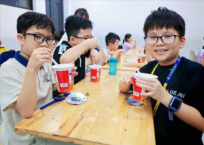Học sinh Trường tiểu học Nguyễn Viết Xuân được ăn tối trong khi đợi bố mẹ đón về. Ảnh: TTXVN phát