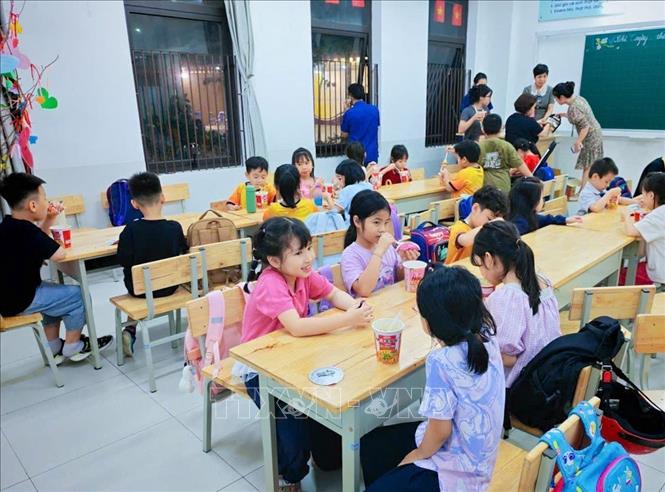 Trường tiểu học Nguyễn Viết Xuân bố trí bữa ăn cho học sinh khi chưa có bố mẹ đón về. Ảnh: TTXVN phát
