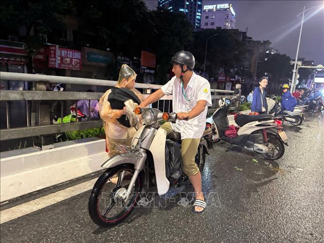 Xe chết máy, không thể khởi động là nguyên nhân khiến nhiều người dân vẫn chưa thể trở về nhà sau khi mưa ngớt. Ảnh: Quốc Khánh - TTXVN