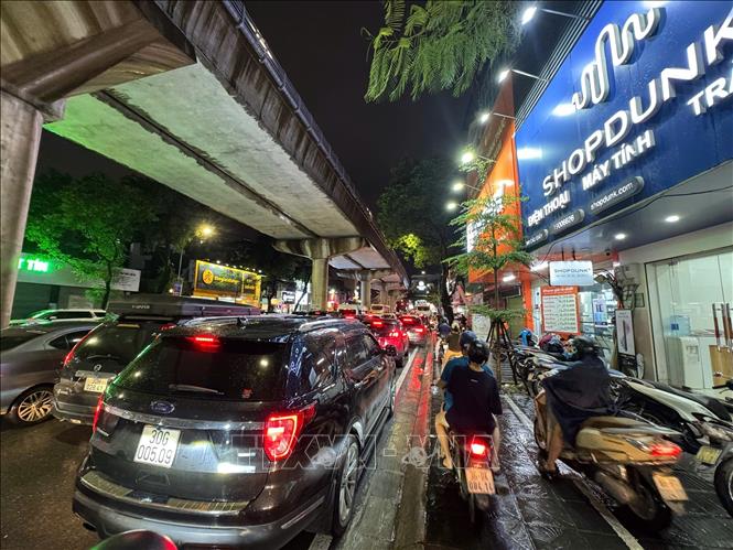 Tối muộn người dân vẫn chen chân giữa dòng xe tại khu vực Xuân Thuỷ. Ảnh: Quốc Khánh - TTXVN