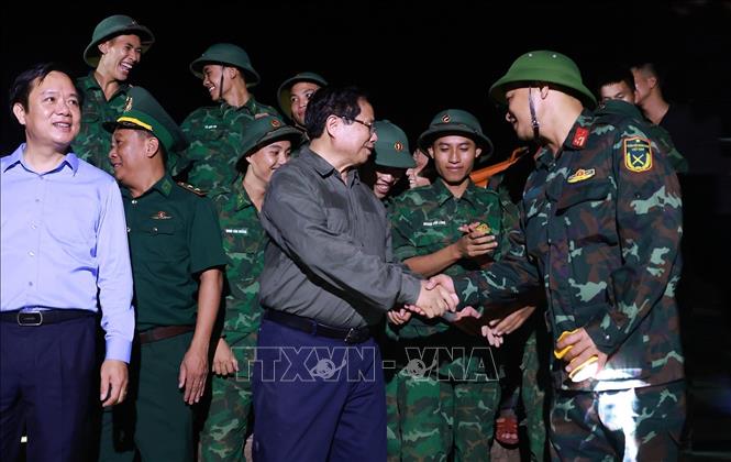 Thủ tướng Phạm Minh Chính động viên, giao nhiệm vụ cho các lực lượng gia cố đê điều, khắc phục hậu quả tại khu vực đê biển Hải Thịnh 3. Ảnh: Dương Giang-TTXVN 
