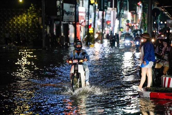 Người dân tìm mọi cách để về nhà sau khi mưa ngớt (ảnh chụp lúc 20h30). Ảnh: Khánh Hoà - TTXVN