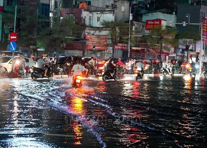 Người dân tìm mọi cách để về nhà sau khi mưa ngớt (ảnh chụp lúc 20h30). Ảnh: Khánh Hoà - TTXVN