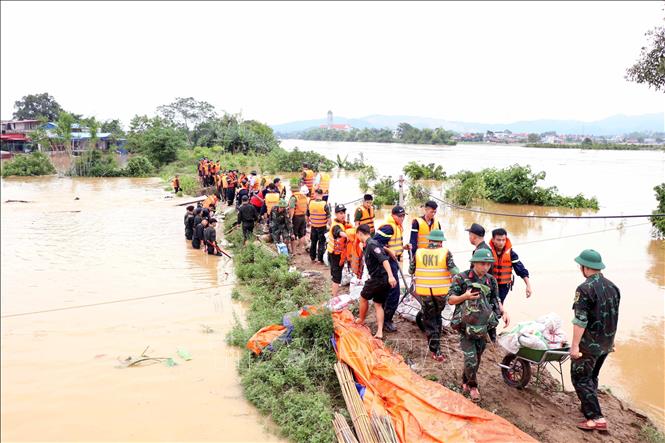 Lực lượng Quân đội và Công an được huy động khắc phục vỡ đê bối sông Cầu. Ảnh: Trần Trang-TTXVN 