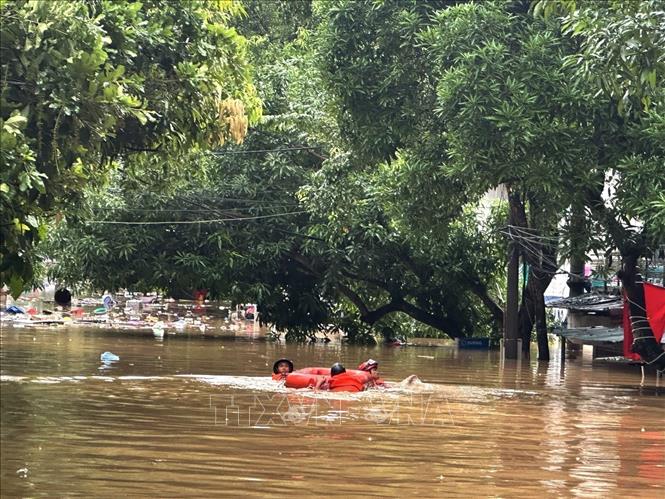 Cán bộ cứu hộ vượt lũ, tiếp cận khu dân cư ngập sâu ở phường Hà Giang 1, tỉnh Tuyên Quang. Ảnh: Minh Tâm-TTXVN