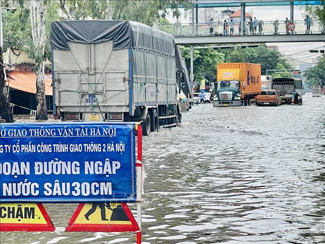 Trên đường Cầu Bươu, đơn vị chức năng phải cắm biển cảnh báo tại những vị trí ngập sâu. Ảnh: Tuyết Mai - TTXVN