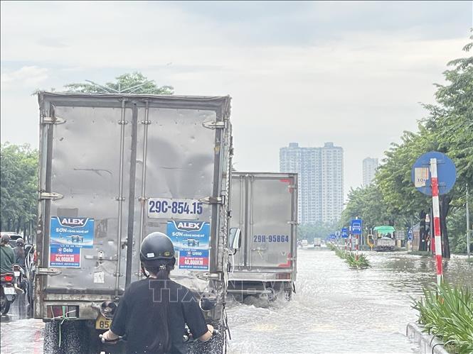 Đường Phạm Tu dẫn về cơ sở Bệnh viện K - cơ sở Tân Triều vẫn ngập nước cả hai bên làn đường, xe máy đều phải quay đầu. Ảnh: Tuyết Mai - TTXVN