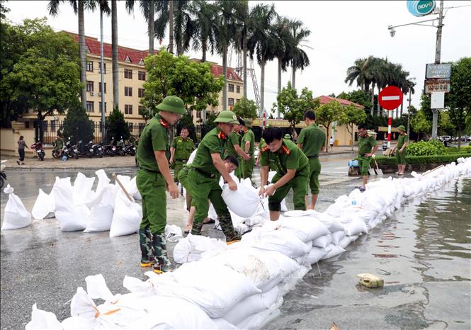 Lực lượng công an Phòng quản lý hành chính, Công an tỉnh Ninh Bình, giúp dân đắp đê tạm chống lũ tại sông Đáy. Ảnh: Nguyễn Chinh - TTXVN