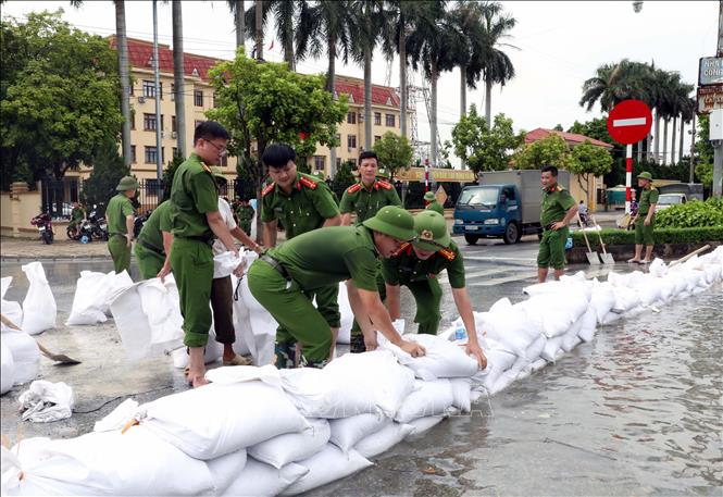 Lực lượng công an phòng  quản lý hành chính công an tỉnh Ninh Bình giúp dân đắp đê tạm chống lũ tại sông Đáy. Ảnh: Nguyễn Chinh - TTXVN