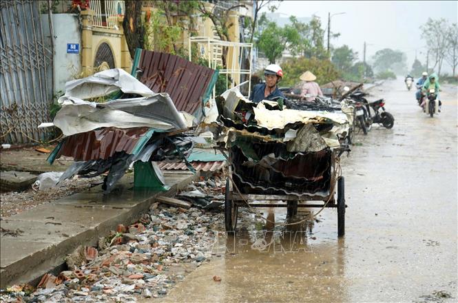 Người dân làng Phượng Mao, xã Hoằng Giang (Thanh Hóa) thu dọn vật dụng dưới đống đổ nát còn lại sau 2 ngày bão số 10 kèm giông lốc đi qua. Ảnh: Việt Hoàng - TTXVN
