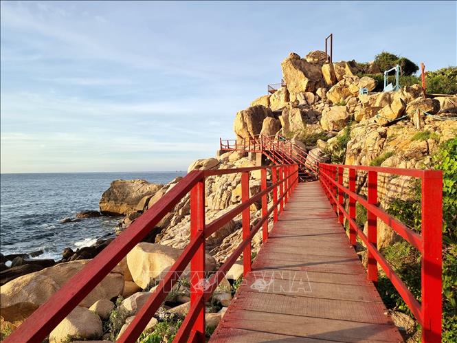 A red wooden bridge curves on the rocky path around Hang Rai. VNA Photo: Nguyễn Thành