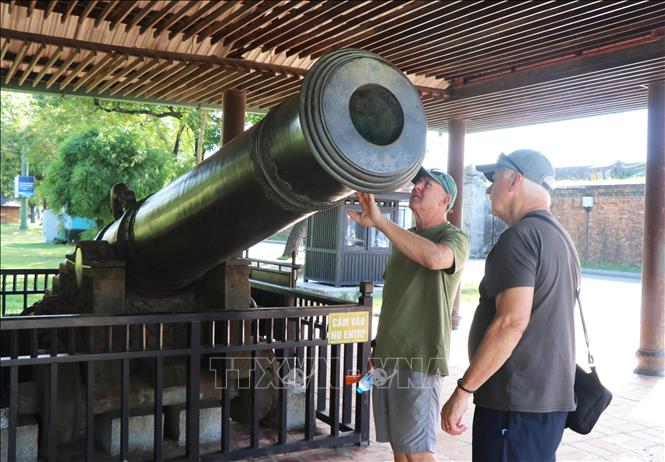 Du khách nước ngoài tham quan khẩu thần công tại Kinh thành Huế, thành phố Huế. Ảnh: Nguyên Lý - TTXVN