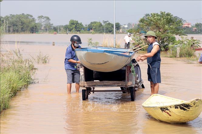Do tuyến đường bị ngập sâu trong nước nhiều người dân xã Sơn Đông đã phải dùng thuyền để di chuyển, gây khó khăn trong việc đi lại của người dân. Ảnh: Tạ Toàn – TTXVN