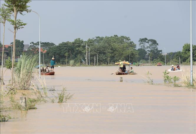 Do tuyến đường bị ngập sâu trong nước nhiều người dân xã Sơn Đông đã phải dùng thuyền để di chuyển, gây khó khăn trong việc đi lại của người dân. Ảnh: Tạ Toàn – TTXVN