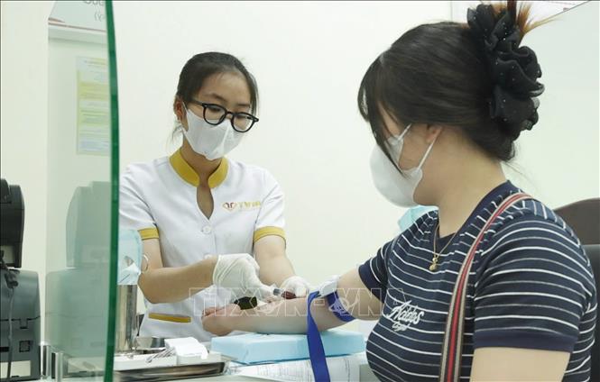 Nhân viên y tế tiến hành lấy mẫu máu một bệnh nhân. Ảnh: Chanh Đa-TTXVN