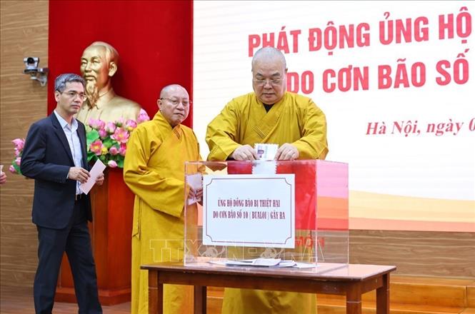 Các cá nhân ủng hộ tiền cho đồng bào bị thiệt hại do cơn bão số 10 gây ra. Ảnh: Minh Đức – TTXVN