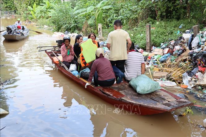 Người dân phải dùng thuyền để đi ra vùng ngập để trông nom nông sản và đàn vật nuôi tại bãi giữa sông Hồng. Ảnh: Vũ Quang – TTXVN