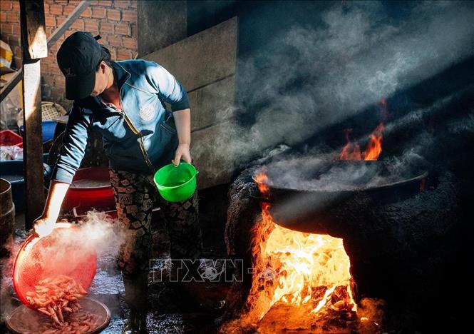 Their work is laborious, working day and night inside small, humid, steamy kitchens, with the purpose of keeping the natural taste of freshly-caught fishes and squids. VNA Photo: Khánh Hoà