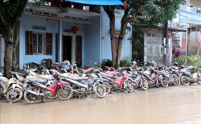 Hàng chục xe máy bị nhấn chìm trong lũ và bùn đất. Ảnh: Đức Thọ - TTXVN