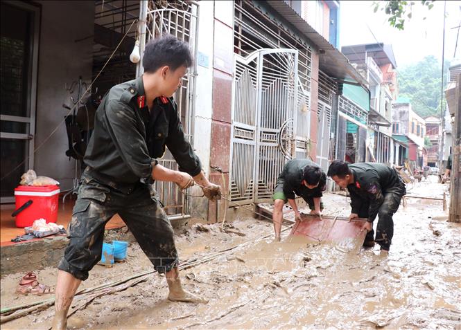 Các chiễn sĩ đồn biên phòng Cửa khẩu Quốc tế Thanh Thủy (Tuyên Quang) giúp người dân dọn vệ sinh sau lũ. Ảnh: Đức Thọ - TTXVN