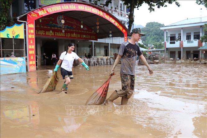 Các phụ huynh và thầy cô trường tiểu học Quang Trung (phường Hà Giang 2, Tuyên Quang) dọn bùn đất trong trường học sau lũ. Ảnh: Đức Thọ - TTXVN
