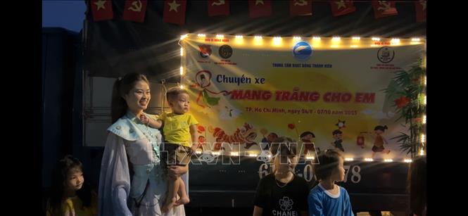 Chiếc xe tải nhỏ được trang trí rực rỡ với lồng đèn giấy, dây kim tuyến và mô hình chị Hằng, chú Cuội, thỏ Ngọc. Ảnh: Huyền Trang - TTXVN 