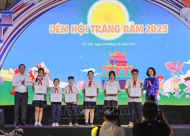 Bà Vũ Thị Thu Hà, Phó Chủ tịch UBND thành phố Hà Nội trao quà cho thiếu nhi. Ảnh: Khánh Hoà - TTXVN