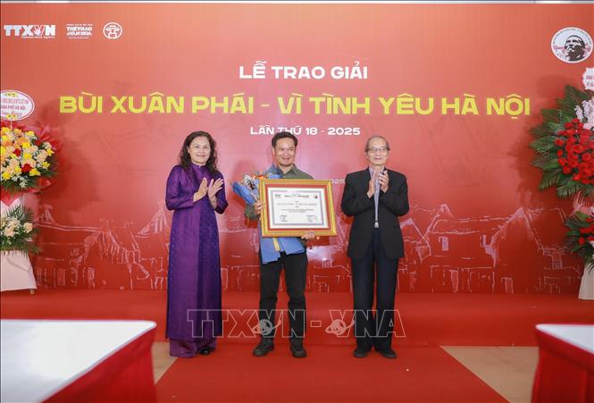 Phó Tổng Giám đốc TTXVN Nguyễn Thị Sự và nhà thơ Bằng Việt, nguyên Chủ tịch Hội VHNT Hà Nội, Chủ tịch Hội đồng Giám Khảo trao Giải Tác phẩm cho Loạt tranh về Hà Nội của họa sĩ Phạm Bình Chương trong 20 năm 