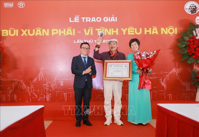Nhà báo Lê Quốc Minh, Ủy viên Trung ương Đảng, Phó Trưởng Ban Tuyên giáo và Dân vận Trung ương và Nhà báo Vũ Việt Trang, Tổng Giám đốc TTXVN trao Giải thưởng Lớn - Vì tình yêu Hà Nội cho Nhạc sĩ Trần Tiến. Ảnh: Phan Phương – TTXVN