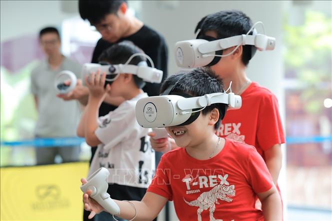Children enjoy the VR experience of visiting Dien Huu pagoda. VNA Photo: Lê Đông