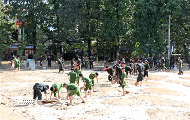 Lực lượng Công an tỉnh Tuyên Quang dọn những lớp bùn đất sau lũ ở Quảng trường 26/3. Ảnh: Đức Thọ - TTXVN
