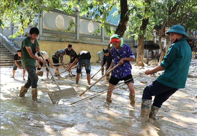 Người dân dọn bùn đất trên các tuyến đường ở phường Hà Giang 1 (Tuyên Quang). Ảnh: Đức Thọ - TTXVN