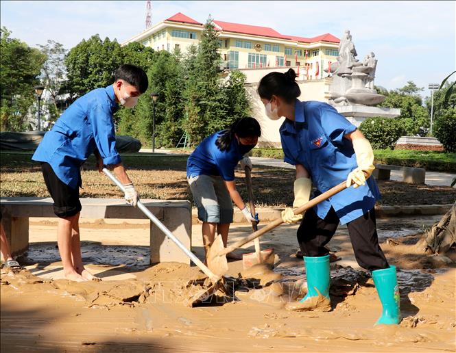 Đoàn viên thanh niên tham gia dọn bùn đất trên các tuyến đường ở phường Hà Giang 1 (Tuyên Quang). Ảnh: Đức Thọ - TTXVN