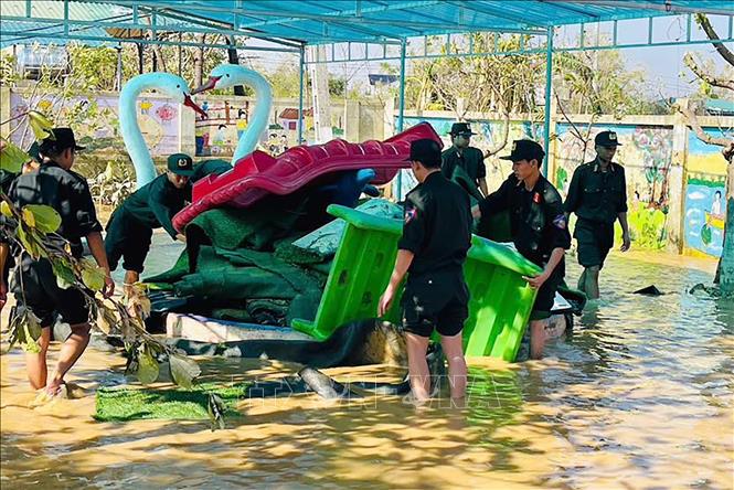 Cán bộ, chiến sĩ Phòng Cảnh sát cơ động, Công an tỉnh Hà Tĩnh hỗ trợ dọn dẹp tại trường mầm non Xuân Hồng (xã Nghi Xuân). Ảnh: Hữu Quyết - TTXVN