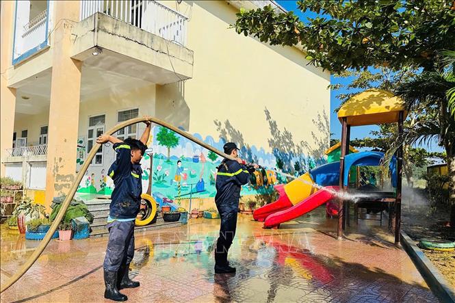Cán bộ, chiến sĩ Phòng Cảnh sát PCCC&CNCH (Công an tỉnh Hà Tĩnh) hỗ trợ dọn dẹp tại trường mầm non xã Kim Hoa. Ảnh: Hữu Quyết - TTXVN