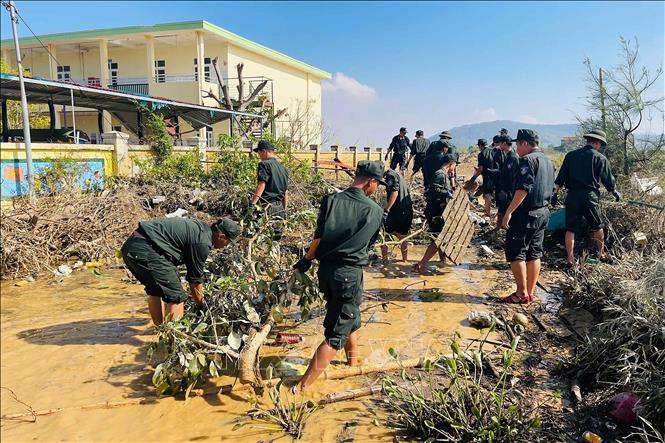 Cán bộ, chiến sĩ Phòng Cảnh sát cơ động, Công an tỉnh Hà Tĩnh hỗ trợ dọn dẹp tại trường mầm non Xuân Hồng (xã Nghi Xuân). Ảnh: Hữu Quyết - TTXVN