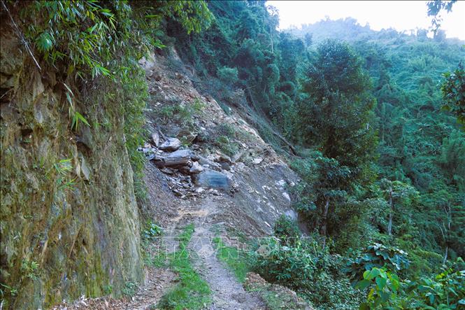 Hàng trăm khối đất, cây rừng và vô số những tảng đá nặng hàng tấn trên vách núi Pù Hiêng đổ xuống, che kín mặt đường trên suốt chiều dài hàng chục mét. Ảnh: Xuân Tiến - TTXVN 