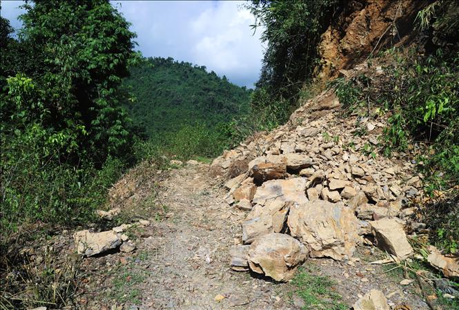 Một điểm sạt từ vách ta-luy dương trên đường vào bản Na Ngân. Hàng tấn đá đã đổ sập từ độ cao hơn 10m xuống mặt đường. Ảnh: Xuân Tiến - TTXVN 
