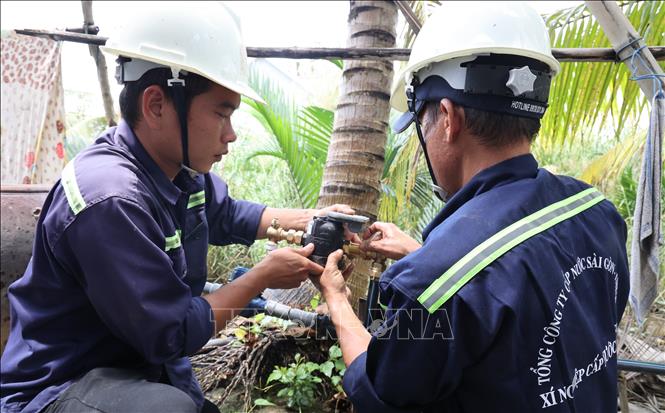 Công nhân Xí nghiệp Cấp nước Cần Giờ lắp đặt đồng hồ nước thông minh đến từng hộ dân ở cù lao Mỹ Khánh, xã Bình Khánh. Ảnh: Anh Tuấn – TTXVN