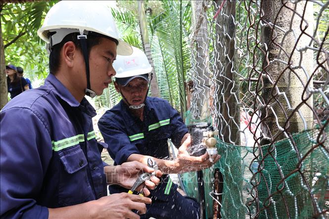 Công nhân Xí nghiệp Cấp nước Cần Giờ lắp đặt đồng hồ nước thông minh đến từng hộ dân ở cù lao Mỹ Khánh, xã Bình Khánh. Ảnh: Anh Tuấn – TTXVN