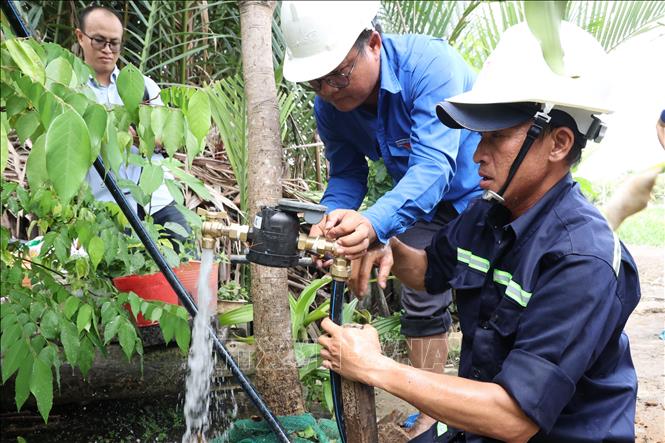 Công nhân Xí nghiệp Cấp nước Cần Giờ lắp đặt đồng hồ nước thông minh đến từng hộ dân ở cù lao Mỹ Khánh, xã Bình Khánh. Ảnh: Anh Tuấn – TTXVN