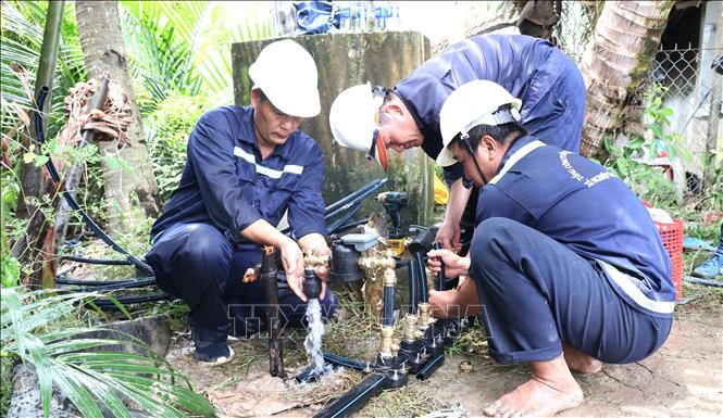Công nhân Xí nghiệp Cấp nước Cần Giờ lắp đặt đồng hồ nước thông minh đến từng hộ dân ở cù lao Mỹ Khánh, xã Bình Khánh. Ảnh: Anh Tuấn – TTXVN