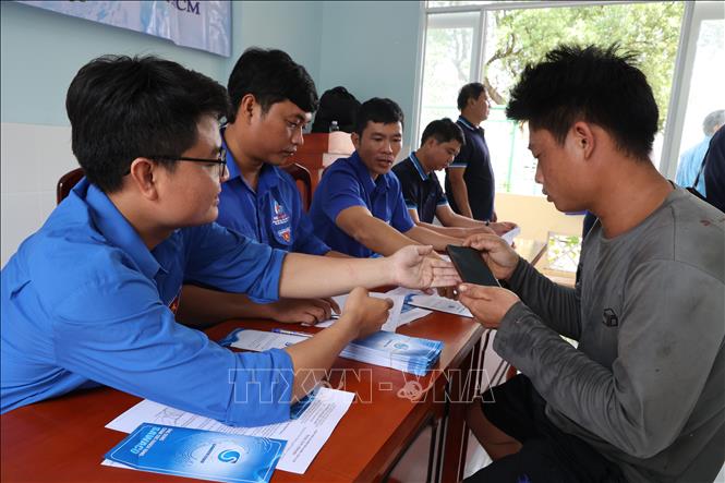 Nhân viên Xí nghiệp cấp nước Cần Giờ hướng dẫn người dân ở Cù lao Mỹ Khánh cài đặt ứng dụng chăm sóc khách hàng và đóng tiền nước online qua ứng dụng thanh toán. Ảnh: Anh Tuấn – TTXVN
