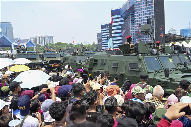 Người dân Indonesia chứng kiến đoàn xe bọc thép diễu hành tại lễ kỷ niệm. Ảnh: Minh Thái - Phóng viên TTXVN tại Indonesia.