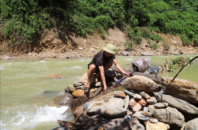 Cả bản bị mất điện từ nhiều ngày qua nên nhiều hộ dân phải sử dụng máy phát điện bằng sức nước để có nguồn điện thắp sáng. Ảnh: Xuân Tiến - TTXVN