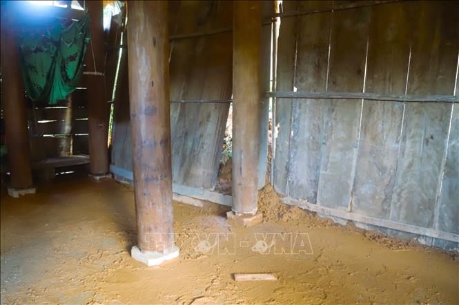 Đất đá, bùn nhão từ vách ta-luy dương sạt lở xuống gây hư hỏng hệ thống thưng ván bao quanh nhà và chảy bùn đất vào nhà. Ảnh: Xuân Tiến - TTXVN
